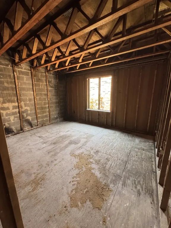 A room taken down to the framing and subfloor after a house fire.